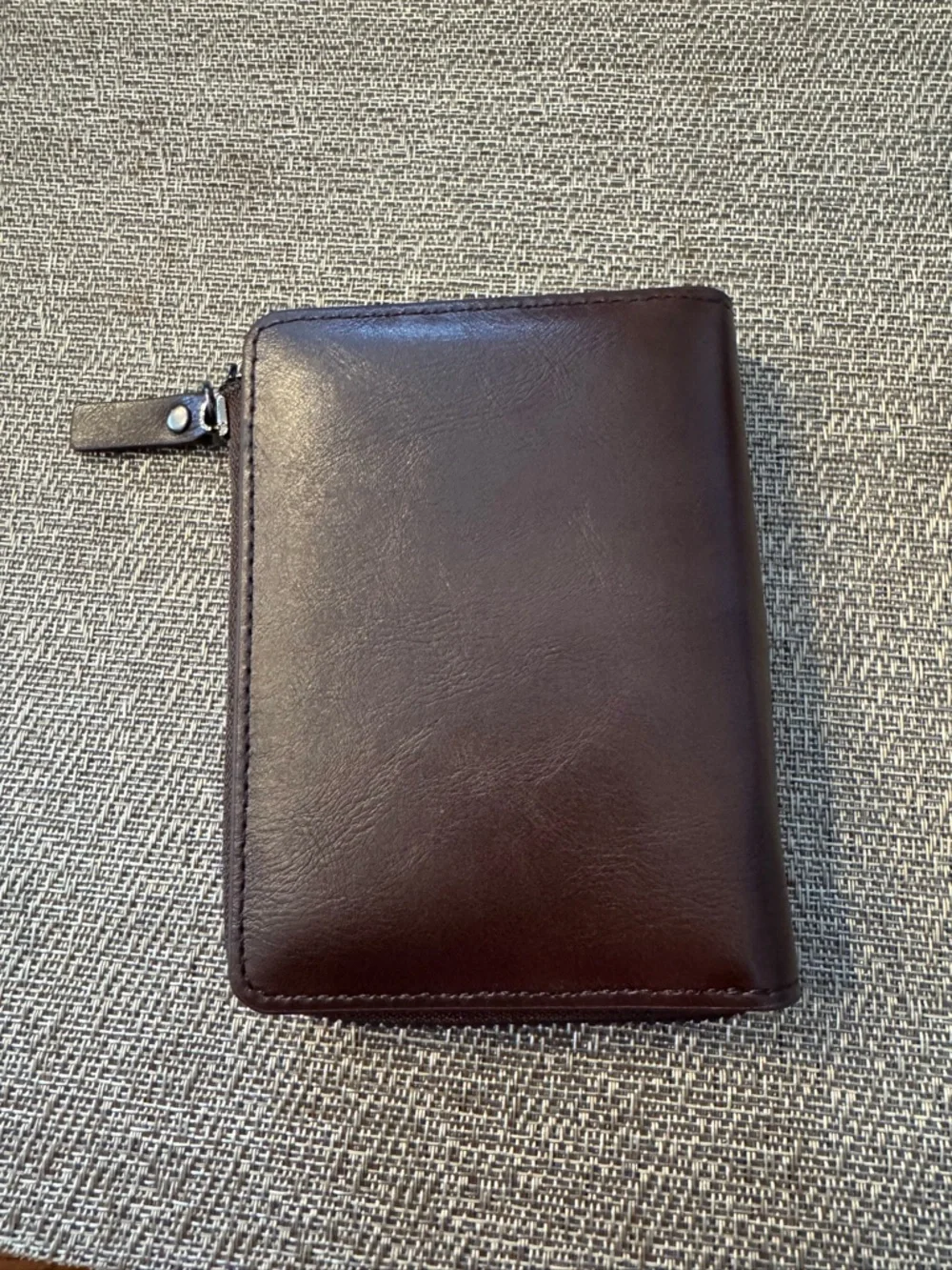 Men’s zip leather wallet in brown.‎